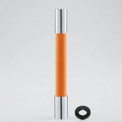 An orange cylindrical cosmetic tube with shiny silver metallic caps, shown standing upright on a light gray background with a small black ring accessory placed beside it.