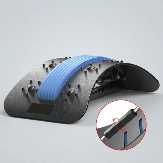 A black textured massage or therapy pad with a curved shape, featuring a blue ribbed strip across the center and small raised nubs. A circular inset at the bottom right shows a close-up detail of the attachment mechanism.