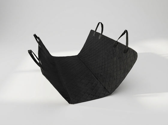 A black quilted face mask with integrated ear loops, displayed on a clean light gray studio background.