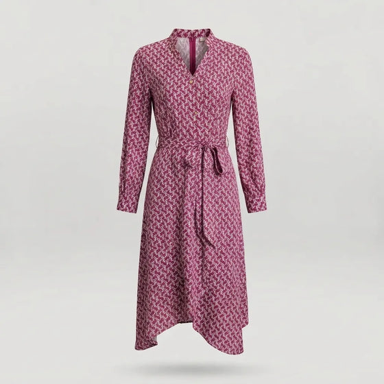 A long-sleeve wrap dress with a geometric pattern in pink and dark red, featuring a tie belt at the waist and a split neckline, shown against a light gray background.