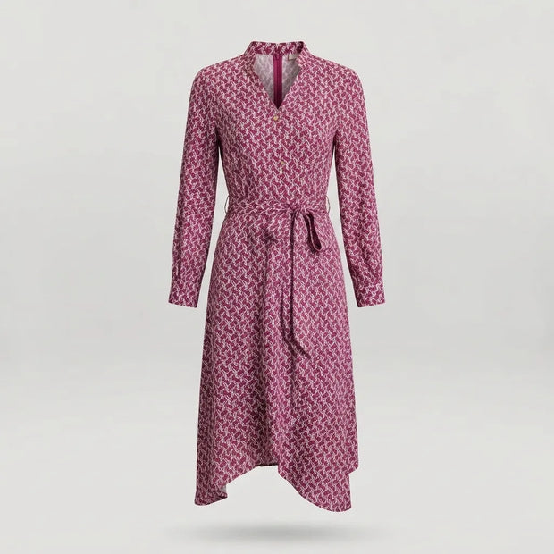 A long-sleeve wrap dress with a geometric pattern in pink and dark red, featuring a tie belt at the waist and a split neckline, shown against a light gray background.