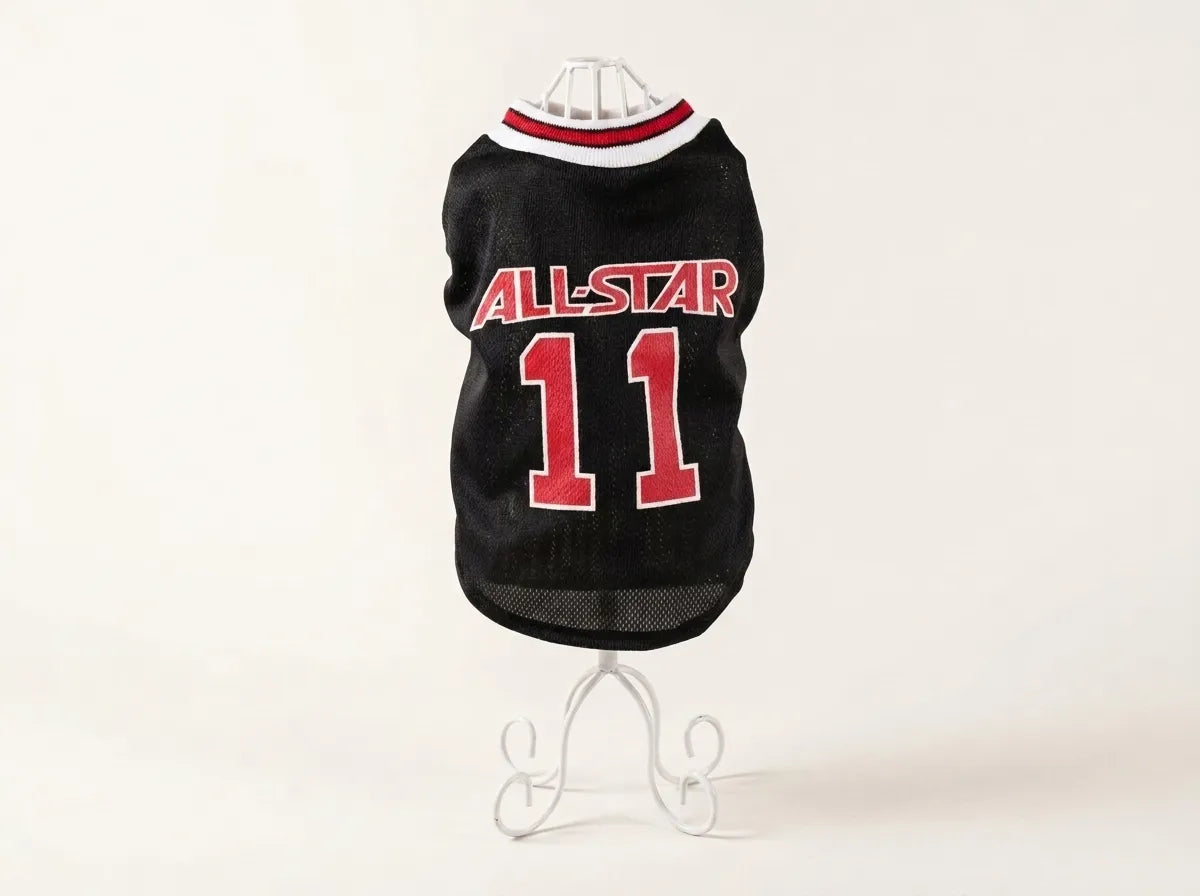 A black pet sports jersey with 'ALL-STAR' and the number '11' in red, displayed on a white wire stand against a plain white background.