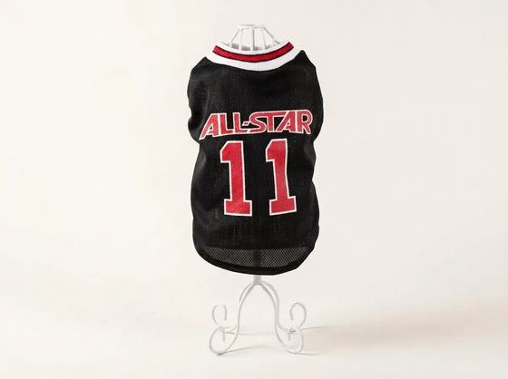 A black pet sports jersey with 'ALL-STAR' and the number '11' in red, displayed on a white wire stand against a plain white background.