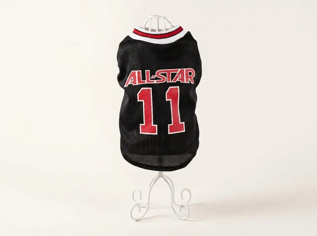 A black pet sports jersey with 'ALL-STAR' and the number '11' in red, displayed on a white wire stand against a plain white background.