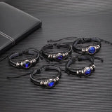 Set of black leather bracelets with blue stones on a textured surface