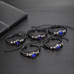 Set of black leather bracelets with blue stones on a textured surface