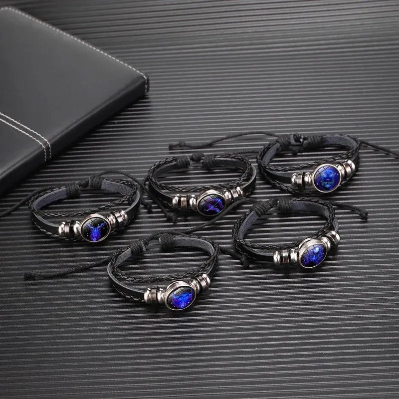 Set of black leather bracelets with blue stones on a textured surface