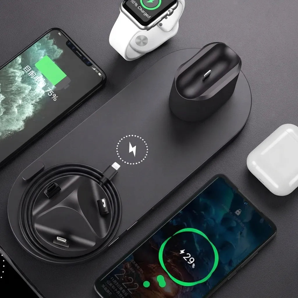 A black multi-device wireless charging pad shown with a smartphone, smartwatch, earbud charging case, and another charging phone on a dark gray surface.