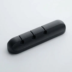 A black plastic 3-hole cable guard or cable protector with a rounded rectangular shape, shown on a light gray background.