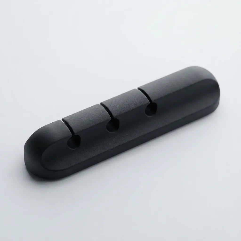 A black plastic 3-hole cable guard or cable protector with a rounded rectangular shape, shown on a light gray background.