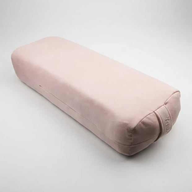 A dusty pink fabric yoga support pillow, also known as a bolster or strapless bolster, shown on a neutral light gray background. The brand name 'yebib' is subtly embroidered on the lower right corner.
