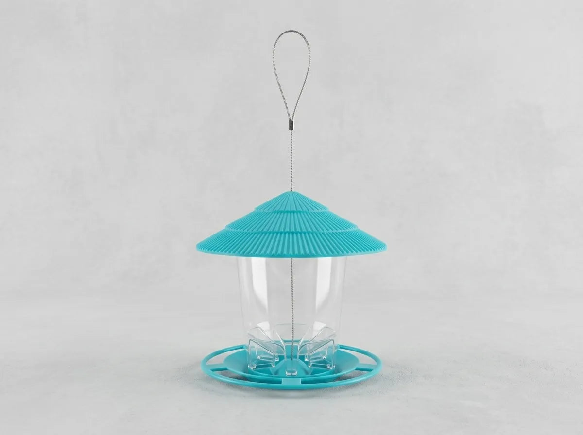 A bird feeder with a bright turquoise blue conical lid, a clear plastic cup in the center, and a matching turquoise base, suspended by a thin metal wire loop against a light gray background.