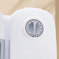 Close-up of a white plastic timer dial with a circular black-and-white countdown scale, set against a warm beige background.