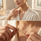 A woman wearing a delicate gold necklace with a row of small heart-shaped pavé settings, shown in a warm indoor setting with a close-up of the pendant being held between fingers.