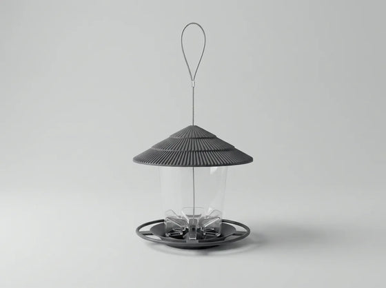 A modern bird feeder with a dark gray ribbed conical roof, a clear cylindrical body, and a circular base with a hanging loop, shown on a light gray background.