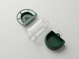 A clear plastic bottle shown disassembled with its green lid and green base components on a light gray background.