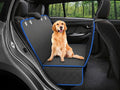 A golden retriever dog sits on a black quilted car seat cover with blue trim installed in the back of a vehicle. The product is shown in a real car interior with trees visible through the window, making this a Lifestyle image.