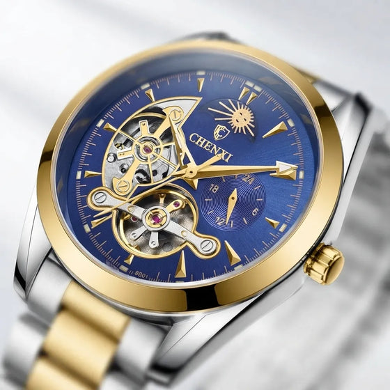 A close-up of a Chiwi skeleton watch with a blue dial, gold-tone case bezel, and two-tone silver and gold metal bracelet.
