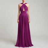 A woman modeling a floor-length magenta purple halter gown with a keyhole cutout at the bust and a pleated draped bodice, set against a light gray studio background.