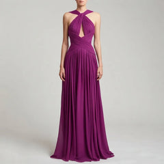 A woman modeling a floor-length magenta purple halter gown with a keyhole cutout at the bust and a pleated draped bodice, set against a light gray studio background.