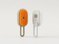 Two pet grooming brushes standing upright on a light gray background. One brush is beige with bright orange bristles, and the other is white with white bristles and a small circular button.