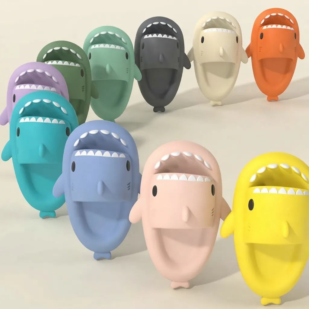 A group of cartoon shark-shaped objects in multiple colors, including teal, blue, pink, yellow, orange, green, gray, and purple, arranged on a plain light background.