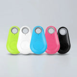 Five small teardrop-shaped electronic trackers in lime green, white, blue, pink, and black, arranged in a row on a light gray background.