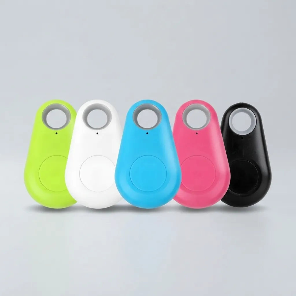 Five small teardrop-shaped electronic trackers in lime green, white, blue, pink, and black, arranged in a row on a light gray background.