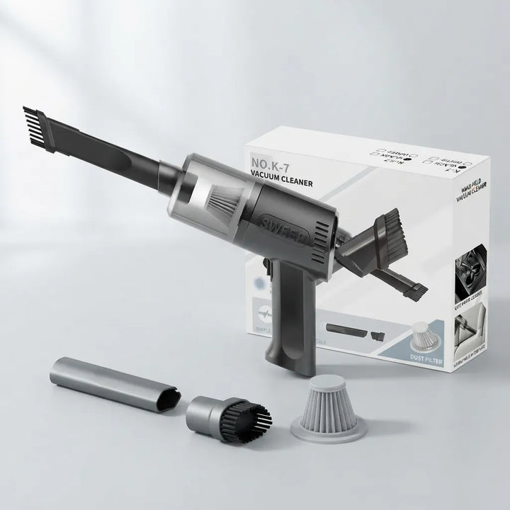 A handheld cordless vacuum cleaner in dark gray and black, shown with its white retail box and several included attachments on a clean light gray studio background. The box reads 'NO.