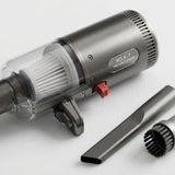A brushed-metal cordless vacuum cleaner with a transparent dust cup, white filter, red switch, and two detachable attachments on a clean white background.