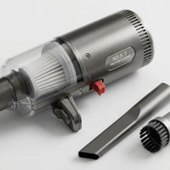 A brushed-metal cordless vacuum cleaner with a transparent dust cup, white filter, red switch, and two detachable attachments on a clean white background.