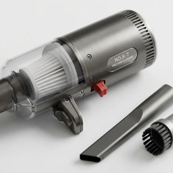 A brushed-metal cordless vacuum cleaner with a transparent dust cup, white filter, red switch, and two detachable attachments on a clean white background.