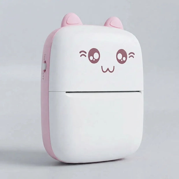 A compact, cute cat-shaped portable device, likely a power bank or mini printer, featuring a white body with a pink side panel, pink ears, and a winking cartoon face on the front.