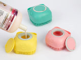 Three small cat-shaped silicone shampoo dispenser brushes in pastel yellow, pink, and mint green, shown on a white background with a bottle pouring shampoo into the yellow one.