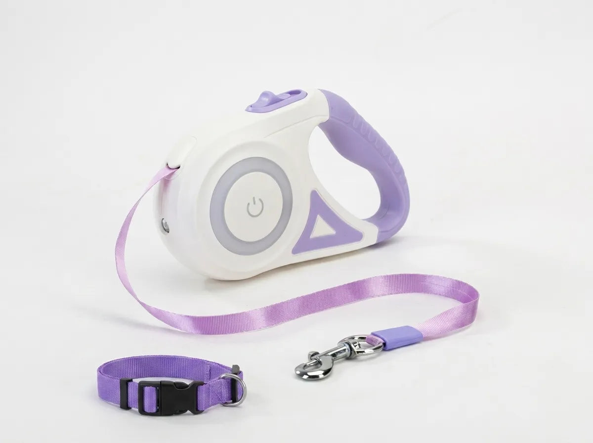 A white and lavender retractable pet leash with a matching lavender strap, shown on a clean white background. The leash includes a purple handle, a purple retractable strap, a separate purple quick-release buckle strap, and a silver metal clasp.