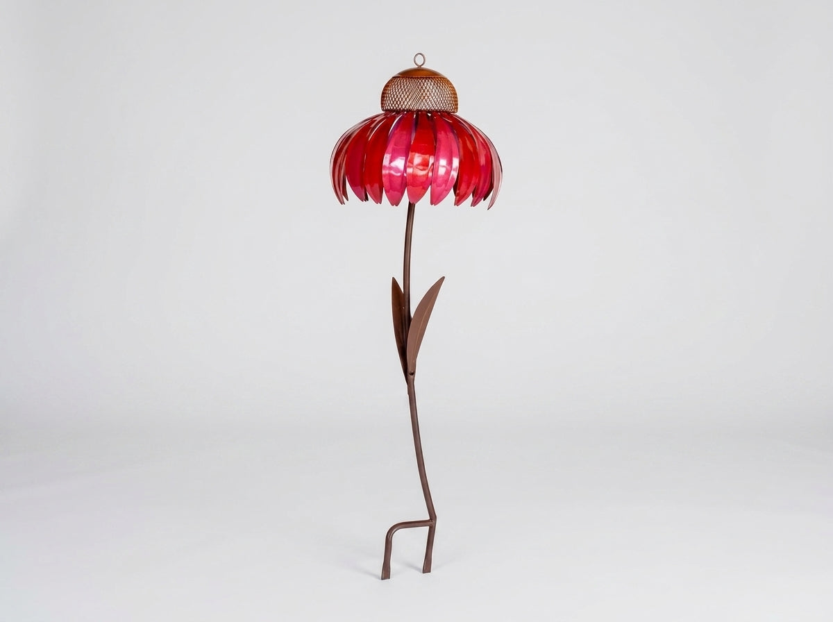 A metal flower garden stake sculpture with a vibrant red petal-shaped top, a brown mesh center, and a long brown stem with leaves, standing on a white studio background.