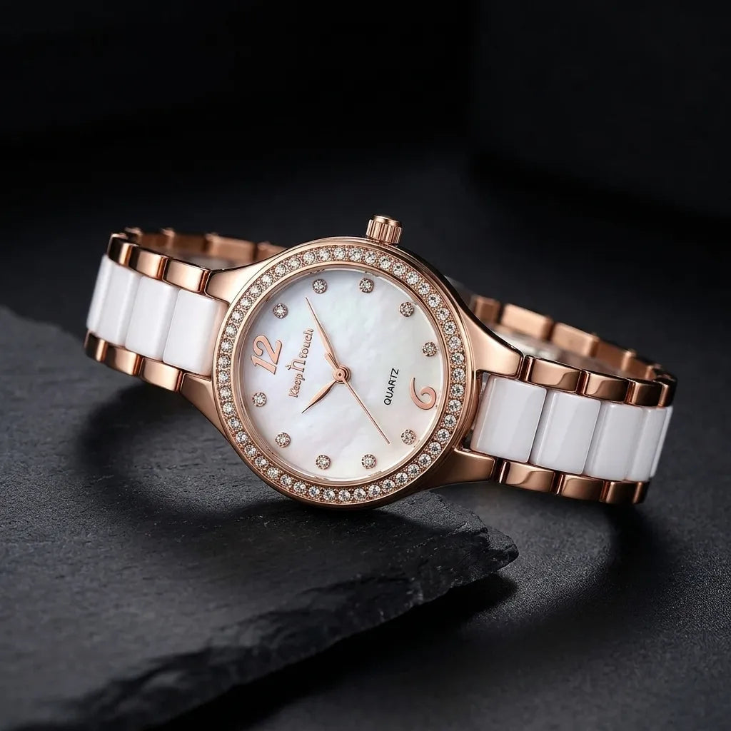 A women's quartz watch with a rose gold metal bracelet, white ceramic links, and a white mother-of-pearl dial accented with rhinestones.