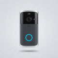 A modern smart video doorbell with a black and dark gray face, silver metallic edges, a central camera lens, and a glowing blue circular indicator light, shown floating against a light gray background.