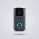 A modern smart video doorbell with a black and dark gray face, silver metallic edges, a central camera lens, and a glowing blue circular indicator light, shown floating against a light gray background.