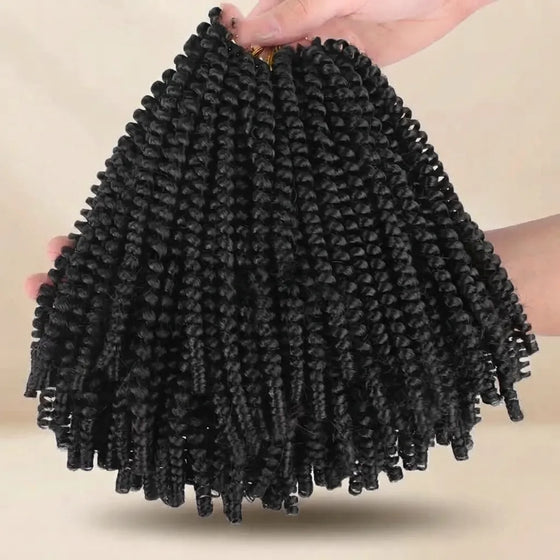 Black curly cornrow hair extensions held up by hands against a plain beige background.