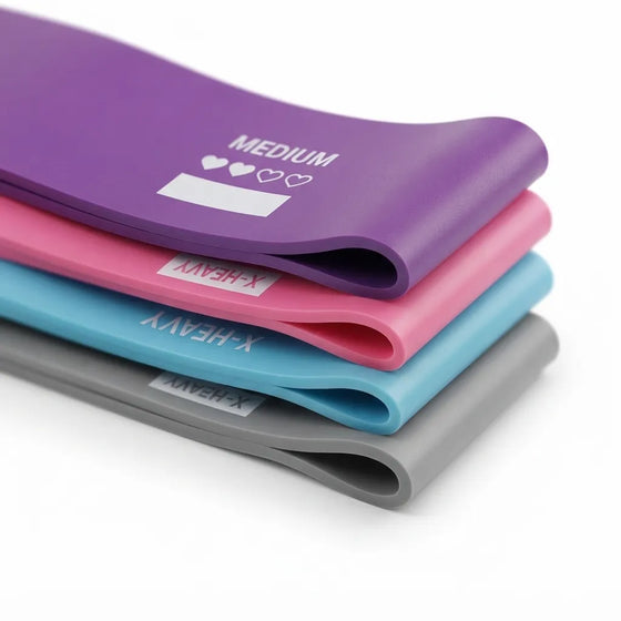 Four resistance bands stacked diagonally on a white background, showing purple, pink, light blue, and gray colors with white printed text indicating weight levels.