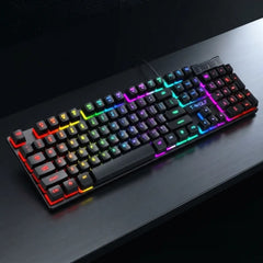 A full-sized mechanical gaming keyboard with RGB rainbow backlighting, resting on a dark wooden desk.