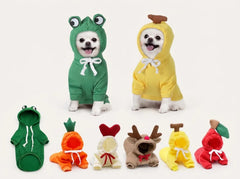 Six small dogs wearing colorful hooded pet costumes are shown against a plain light background, with five matching costume pieces laid out below. The costumes include frog, banana, carrot, chicken, reindeer, and apple designs.