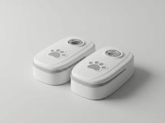 Two small white rectangular containers with rounded corners, shown on a light gray studio background. Each container has a gray paw print graphic on the lid and a circular clear window near the top.