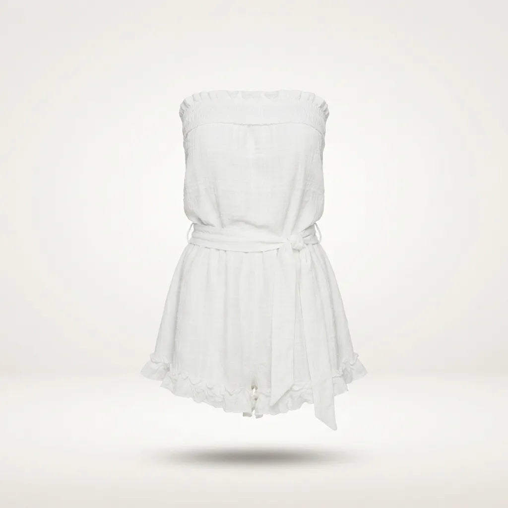 A white strapless romper with a ruffled neckline, a matching fabric tie belt at the waist, and a ruffled hem, shown floating against a light off-white background.