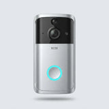 A modern wireless video doorbell with a silver and black finish, featuring a glowing cyan LED ring around the central button, shown against a light gray background.