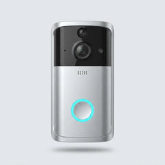 A modern wireless video doorbell with a silver and black finish, featuring a glowing cyan LED ring around the central button, shown against a light gray background.