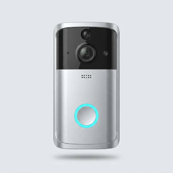 A modern wireless video doorbell with a silver and black finish, featuring a glowing cyan LED ring around the central button, shown against a light gray background.
